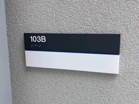Room 1038 identification plaque mounted on a textured wall