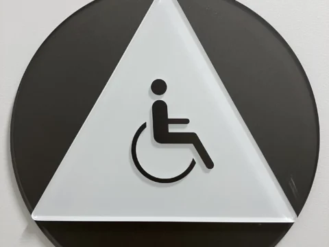 Geometric wheelchair accessibility symbol mounted on a wall