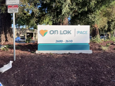On Lok PACE exterior monument sign beside a landscaped entrance