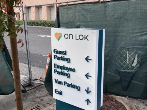 On Lok wayfinding sign with directions to parking and entrances