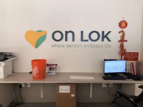 On Lok reception wall with dimensional logo and brand tagline