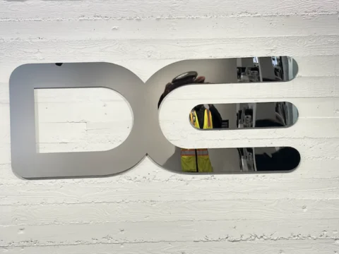 Dimensional DC logo mounted on a white textured feature wall