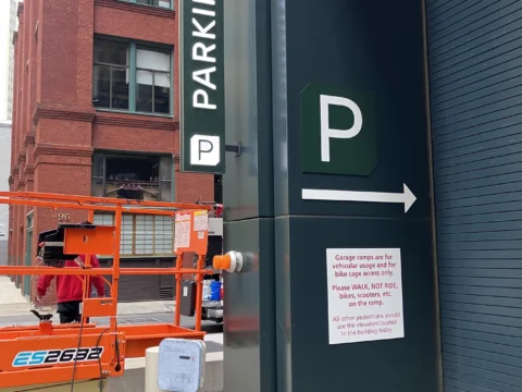 Exterior parking wayfinding sign with directional arrow