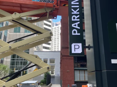 Vertical parking identification sign on a city building facade