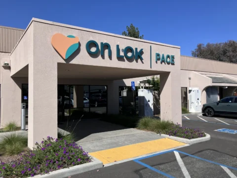On Lok PACE branded entrance facade viewed from the parking lot