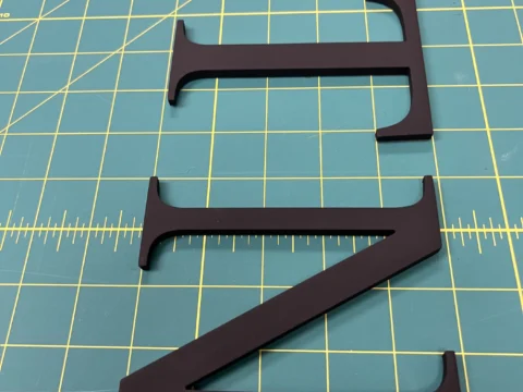 Dark dimensional letters arranged for a custom sign installation