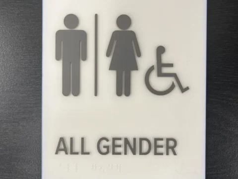 All-gender accessible restroom plaque with tactile symbols