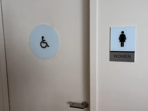 Accessible restroom identification symbols on adjacent doors