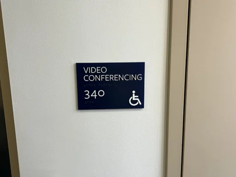 Video conferencing room 340 identification sign beside a door
