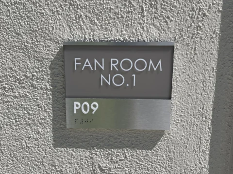 Fan room P09 identification sign on a textured wall