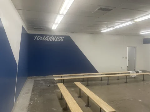 Toughness motivational wall lettering above a team bench