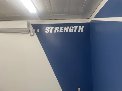 Strength motivational lettering installed high on a blue wall