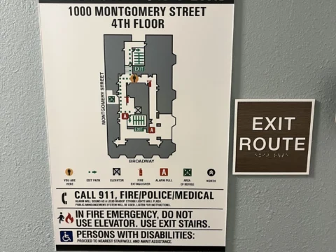 Evacuation plan and exit route sign mounted beside a doorway
