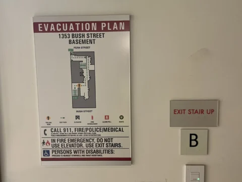 Evacuation plan and elevator B identification signs on a wall
