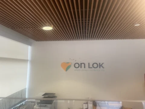 On Lok dimensional logo mounted on an interior reception wall