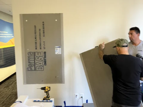 Installer positioning a metal recognition panel on the wall