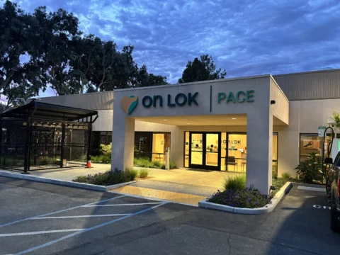 Illuminated On Lok PACE entrance sign photographed at dusk