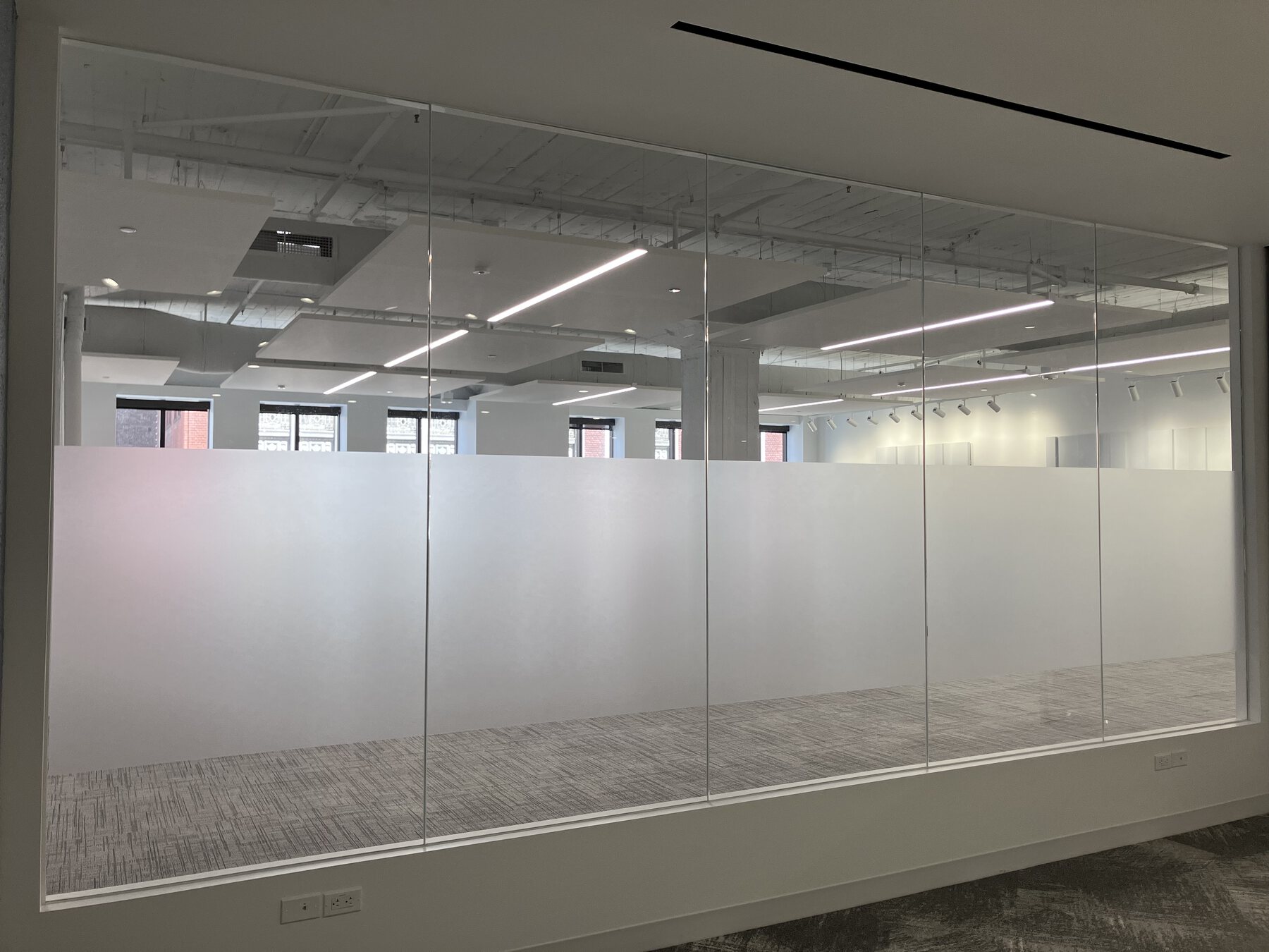 Frosted privacy film installed across commercial glass office partitions