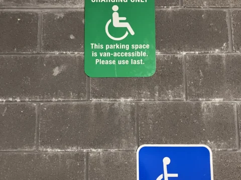 Accessible parking sign installed below an electric vehicle charging notice