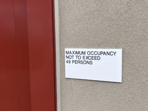 Room occupancy capacity label installed beside an entrance