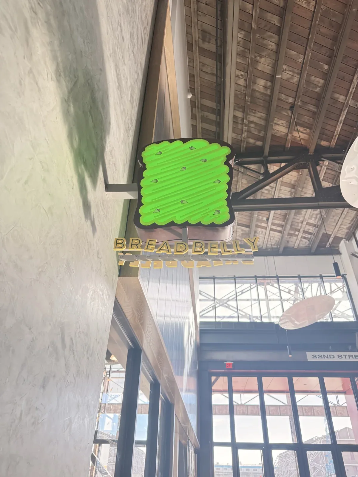 Illuminated Breadbelly blade sign installed inside a commercial food hall