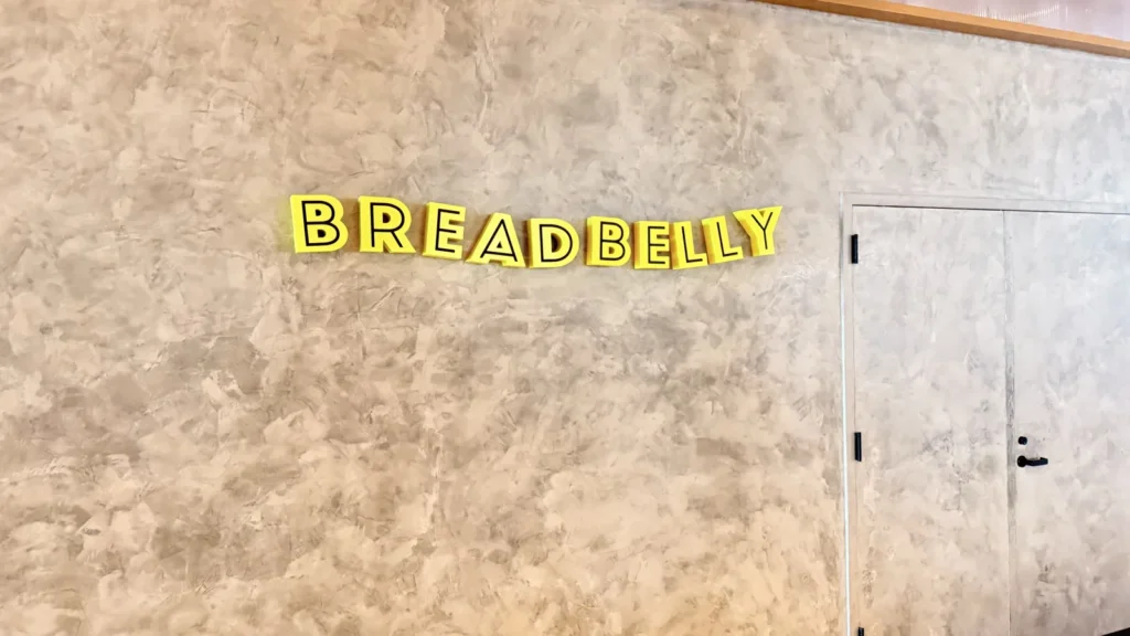Yellow Breadbelly dimensional letters installed on a textured interior wall