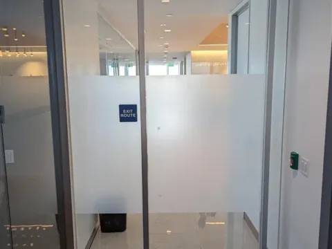 Mid-height frosted privacy film providing privacy on a glass office entry