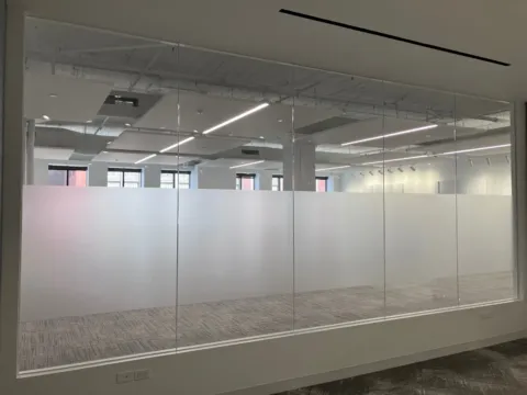 Frosted privacy band installed across a large interior glass office wall