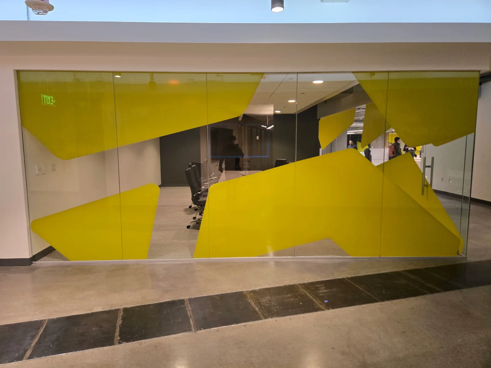 Yellow decorative privacy film creating branded visual screening on a glass conference room