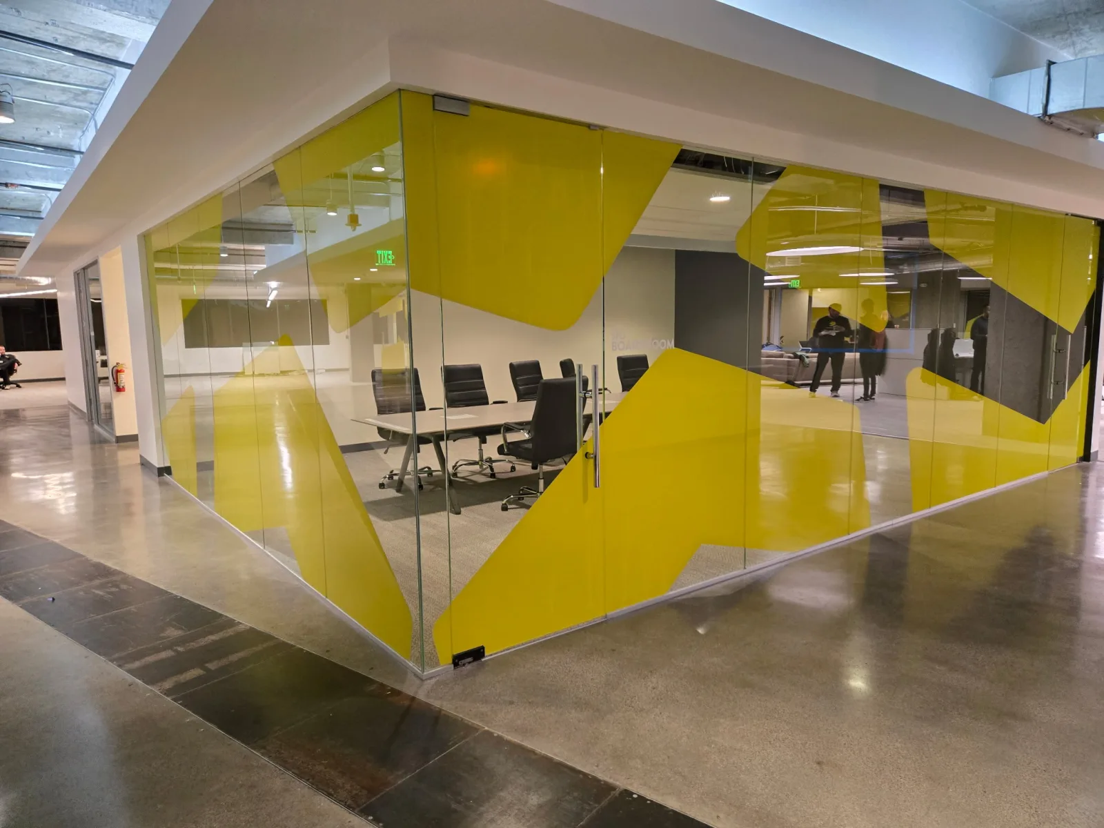 Yellow custom privacy film wrapping the glass walls of a commercial conference room