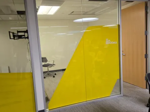 Yellow decorative privacy film applied to a glass office with room identification lettering