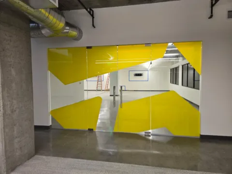 Yellow decorative privacy film applied across three glass-fronted meeting rooms